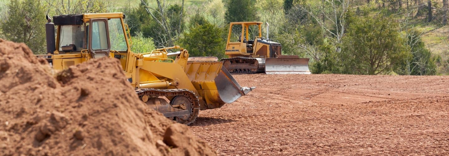 Skid steers clearing land for a forestry mulching project